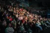 Volles Publikum verfolgt gespannt eine Veranstaltung der KidsDoc-Tour in einer abgedunkelten Eventhalle mit Tribüne.